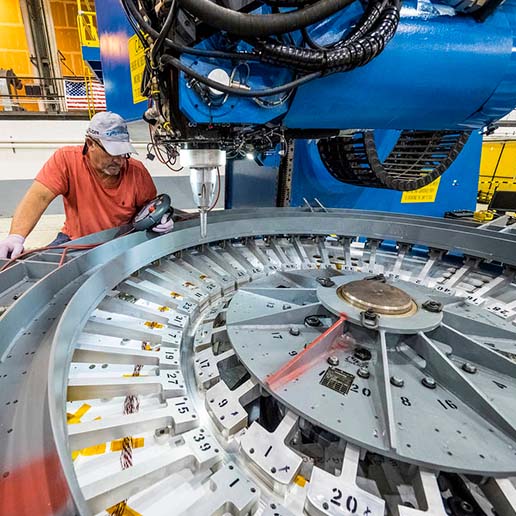 Operator monitoring friction stir welding machine preparing to weld.